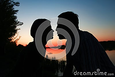 happy couple silhouette against a sunset romance Stock Photo