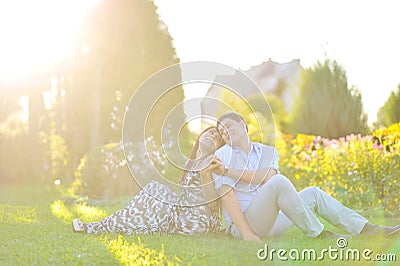 Happy couple sitting back to back to each other Stock Photo