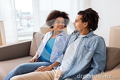 Happy couple sitting on sofa and talking at home Stock Photo