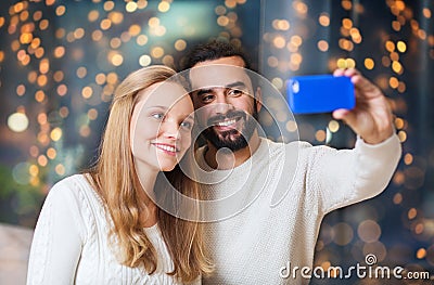 Happy couple with smartphone taking selfie Stock Photo