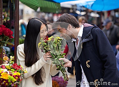 Happy couple smelling flowers together Stock Photo