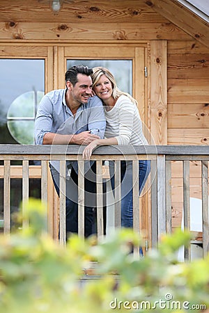 Happy couple standing on terrace smiling Stock Photo