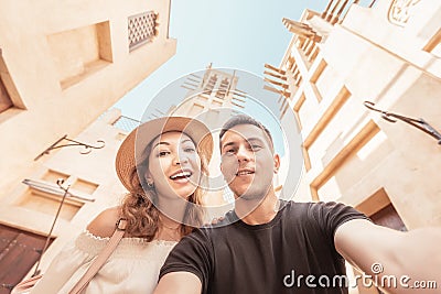 happy couple takes a selfie against the backdrop of ancient Arabic architecture in the old town of Dubai. Honeymoon journey Stock Photo