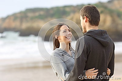 Happy couple of teens hugging and looking each other Stock Photo