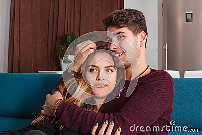 Happy couple thinking and looking sideways sitting on a couch at home Stock Photo