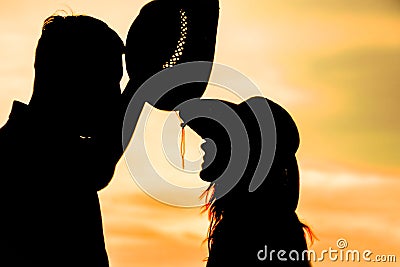 Happy couple together at sunset silhouette of natur Stock Photo