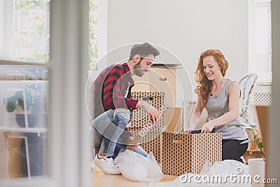 Happy couple unpacking stuff after relocation to new home Stock Photo