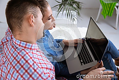 Happy couple using laptop together online. Stock Photo