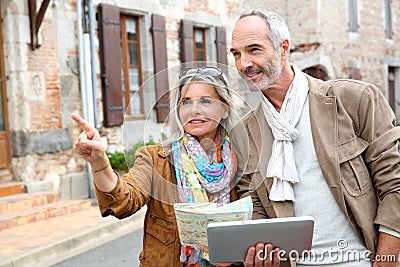 Happy couple visiting old town with tablet in hands Stock Photo