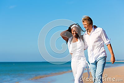 Happy couple walking and running on beach Stock Photo