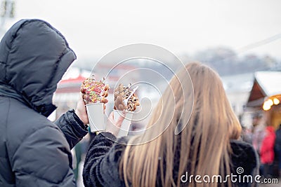 happy couple in warm clothes in love eating bubble waffles at Christmas fair. holidays, winter, christmas and people concept Stock Photo