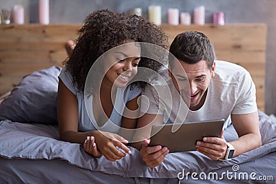 Happy couple watching their wedding photos on a tablet Stock Photo