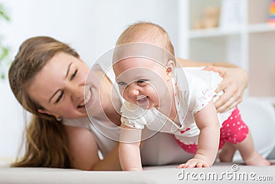 Happy crawling baby girl with mother Stock Photo