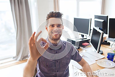 Happy creative male office worker showing ok sign Stock Photo