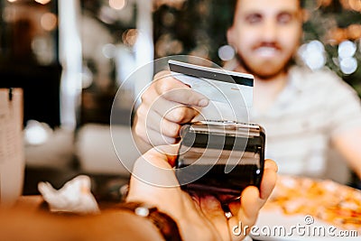 Happy customer paying for lunch using new, modern contactless technology with credit card Stock Photo