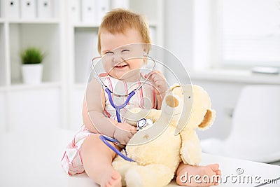 Happy cute baby after health exam at doctor`s office. Medicine and health care concept Stock Photo