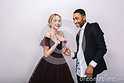 Happy cute couple in-love celebrating Valentine s day on white background. Attractive young blonde woman in luxury dress Stock Photo