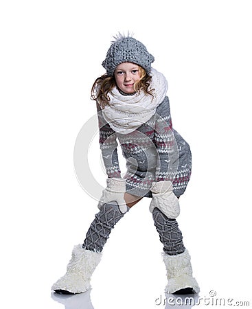 Happy cute kid posing in the studio isolated on white background. Wearing winter clothes. Knitted woolen sweater, scarf, hat Stock Photo