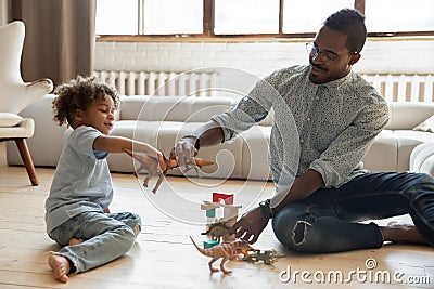 Happy dad and toddler son creating dinosaurs battle Stock Photo