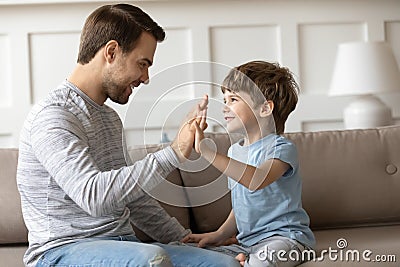 Happy daddy giving high five to smiling little kid son. Stock Photo