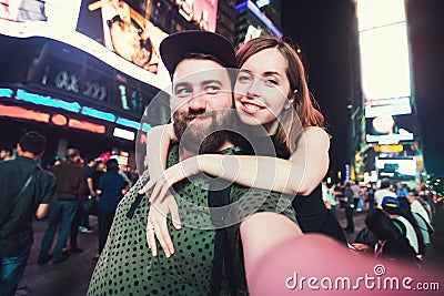 Happy dating couple in love taking selfie photo on Times Square in New York while travel in USA on honeymoon Stock Photo