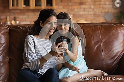 Happy daughter girl and smiling mother resting on couch Stock Photo