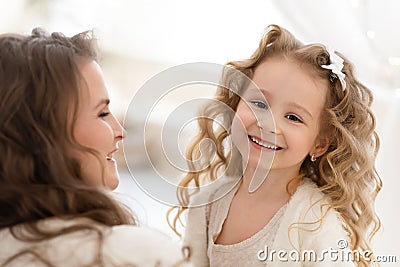 Happy daughter playing with mother. cute baby girl smiling and looking at the camera. Stock Photo