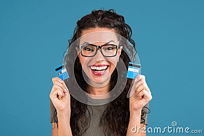 Happy debt free woman holding a credit card cut in two pieces Stock Photo