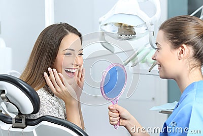 Happy dentist patient checking whitening results Stock Photo