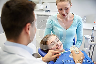 Happy dentist showing toothbrush to patient girl Stock Photo