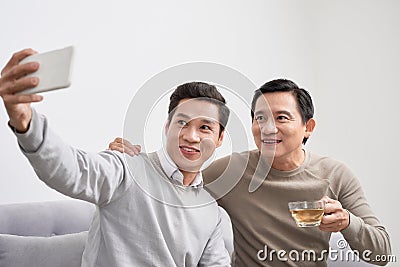 Happy diverse best friends making selfie on mobile phone at home Stock Photo