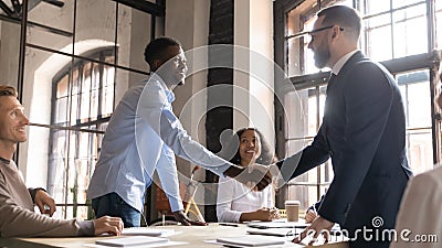 Happy diverse business partners handshaking at group negotiation Stock Photo
