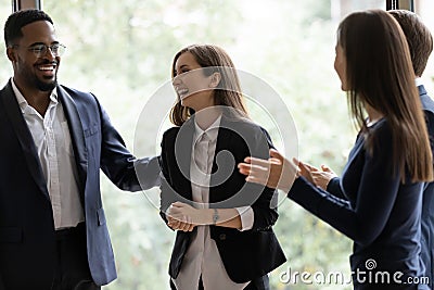 Happy diverse business team applauding coworker success Stock Photo