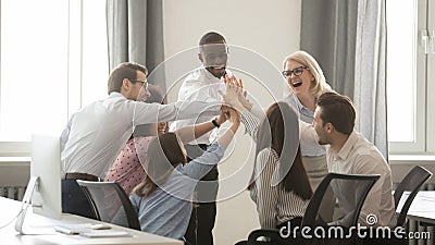 Happy diverse employees business team engaged in teambuilding giving high-five Stock Photo