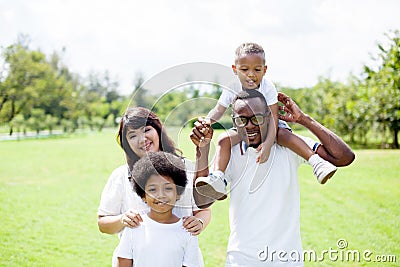 Happy diverse and mixed race family group photo in the park Stock Photo
