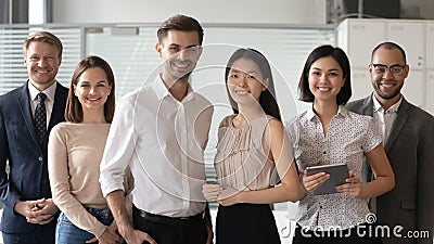 Happy diverse professional leaders looking at camera stand with employees Stock Photo