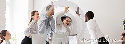 Happy diverse millennial workmates giving high five celebrating corporate success Stock Photo