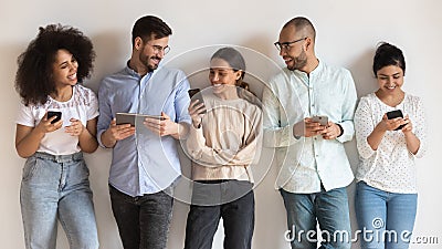 Happy diverse young people using different electronic devices. Stock Photo