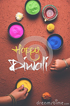 Happy Diwali Greeting card using colourful Rangoli in bowls, diya or clay lamp and happy diwali writing with flowers Stock Photo