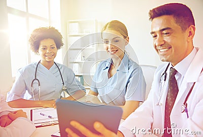 Happy doctors with tablet pc meeting at hospital Stock Photo