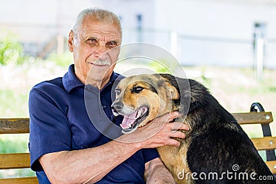 Happy dog pressed against his master. Dog shows his love for owner while resting in park Stock Photo