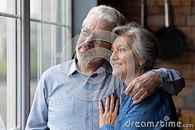 Happy dreamy mature couple hugging, thinking about good future together Stock Photo