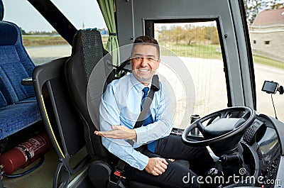 Happy driver inviting on board of intercity bus Stock Photo