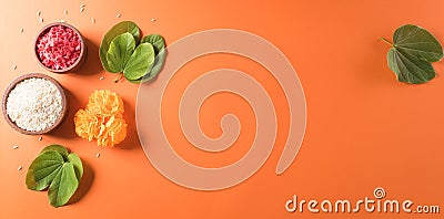 Happy Dussehra. Yellow flowers, green leaf and rice on orange background. Dussehra Indian Festival concept Stock Photo