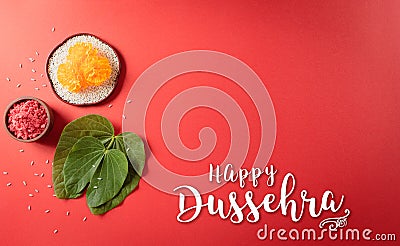 Happy Dussehra. Yellow flowers, green leaf and rice on red background. Dussehra Indian Festival concept Stock Photo