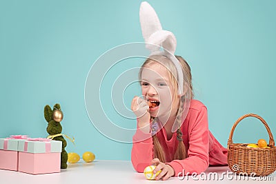 Happy Easter bunny. Child having playing with Easter eggs, eat carrot. Stock Photo