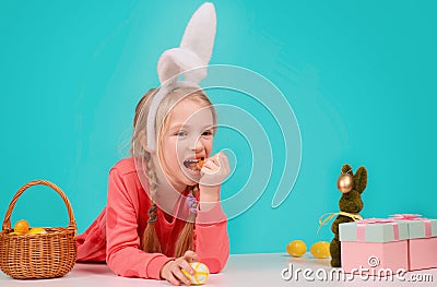 Happy Easter bunny. Child having playing with Easter eggs, eat carrot. Stock Photo