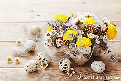 Happy Easter card with colorful flowers, feather and quail eggs on rustic wooden background. Beautiful spring composition. Stock Photo