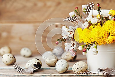 Happy Easter card with colorful flowers, feather and quail eggs on vintage wooden background. Beautiful spring composition. Stock Photo