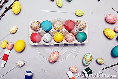 Happy easter. Colored eggs on gray concrete. Flowering, fur-seal willow, on an abstract gray background. Multicolored paints, Stock Photo
